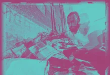 “Metal and Asphalt”: Zander, an American Is A Concrete-Bred Nerd Rapper Zander, an American posing in a squat near the bottom of a pile of scrap metal in Minneapolis, MN as the cover art for his 2024 single "Metal And Asphalt."