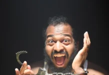 Is Zander, an American “Safe?” Rapper Zander, an American with a manic expression on his face displaying a set of handcuffs unlocked from one wrist as cover art for the single "Safe?"