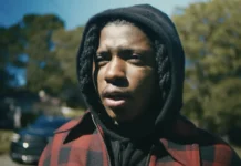 In ‘Saaheem,’ SahBabii Is A Slime Rap All-Star And A Regular Person Rapper SahBabii in a red and black zip-up flannel and black hoodie in a video explaining the meaning of his album 'Do It For Demon'. Feature photo for an article on ATC Sound about SahBabii's 2024 album 'Saheem'.