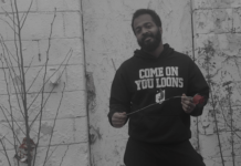 To Zander, an American, “Everything in the hood romantic” Zander, an American holding a rose wearing an MN United hoodie for the "Everything in the hood romantic" music video shot in North Minneapolis