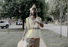 “Done Clocking In”: Zander, an American Drops Late-Stage Capitalism Banger Rapper Zander, an American in a construction vest with a handcuff on his wrist in the "Done Clocking In" music video